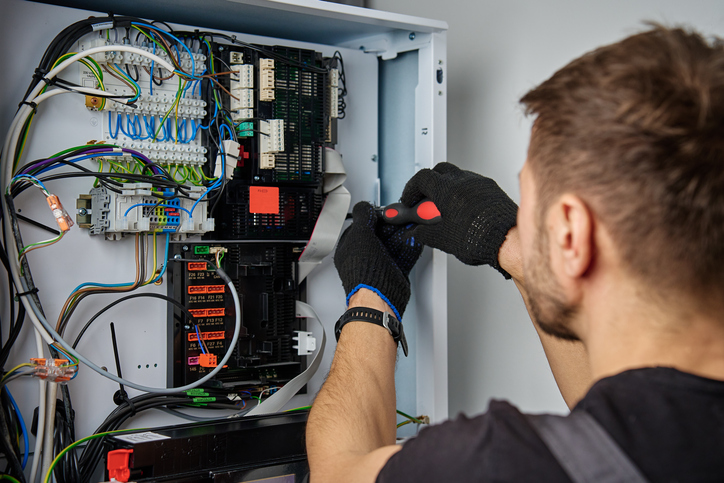 Anytime Comfort technicians repair a heat pump control panel
